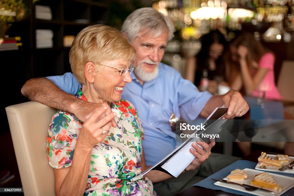 Feliz pareja Senior con desayuno y leer una revista en el Bar - Foto de stock de 2015 libre de derechos