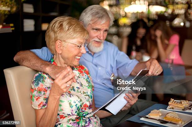 Feliz Pareja Senior Con Desayuno Y Leer Una Revista En El Bar Foto de stock y más banco de imágenes de 2015