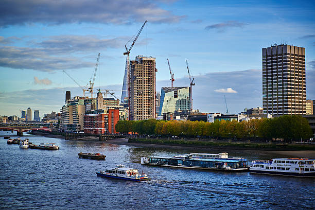 Busy day at River Thames Central London Southern river bank London, United Kingdom - October 30, 2013: South bank of the Thames with construction cranes and skyline. Several boats and ships are passing by. Right side of image is the ITV-building. itv photos stock pictures, royalty-free photos & images