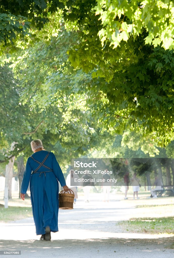 Shaker Village at Pleasant Hill, Kentucky Pleasant Hill, Kentucky - July 7, 2012: An enactor dressed as a Shaker woman carrying a basket,  Shaker Village at Pleasant Hill, KY Kentucky Stock Photo