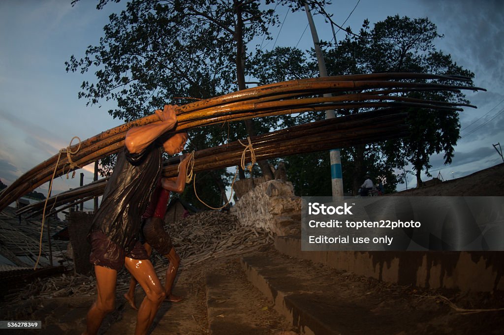 Workers ashore carrying bamboo. Mandalay,Myanmar-July 2,2014 : Daily life of Worker carrying bamboo on Port activities in Ayeyarwaddy river for sell on July 2,2014 in Mandalay city, Central of Myanmar. 2015 Stock Photo