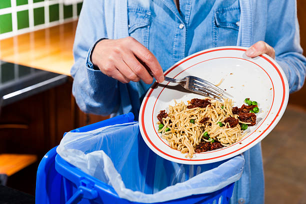 istock Woman scraping food leftovers into bin 536289437