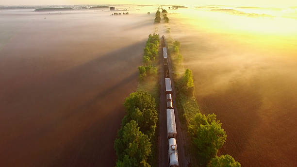 istock Freight train rolls through fog, across breathtaking landscape at sunrise. 536291388