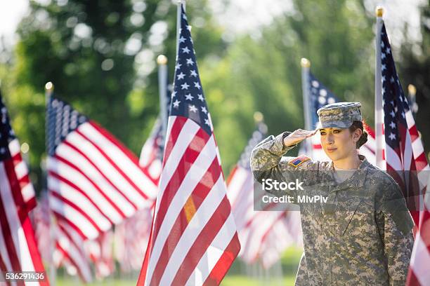 Photo libre de droit de Femme Soldat Américain Saluant Devant Drapeaux Américains banque d'images et plus d'images libres de droit de Faire le salut militaire