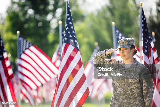 American Female Soldier Saluting In Front Of American Flags Stock Photo - Download Image Now