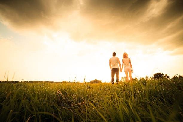 istock couple walking through the field and holding hands 536291741