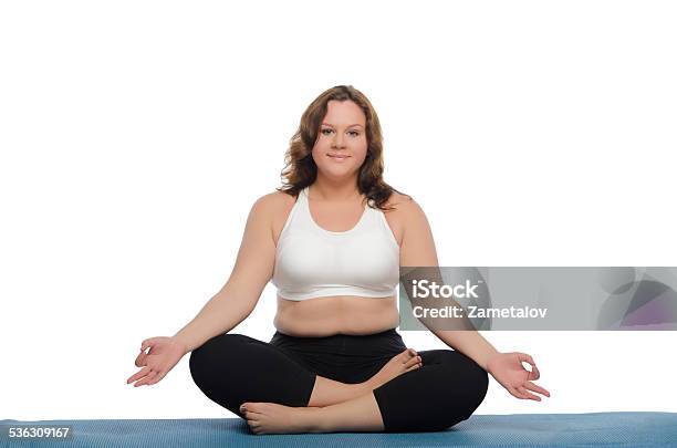 Overweight Woman Practices Yoga On Mat Stock Photo - Download Image Now - Meditating, Overweight, White Background