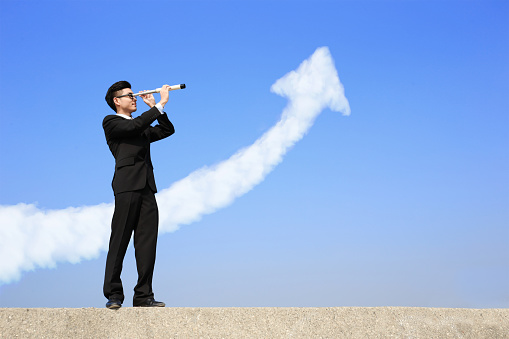 Business man with telescope ( spyglass ) looking forward with growth arrow cloud. a symbol of leadership, success and freedom. asian