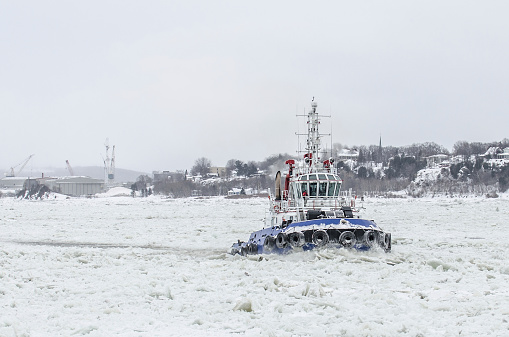 A tugboat in the middle of the ice on the St.Lawrence River during winter
