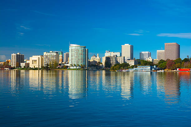 Oakland downtown skyline with reflection on Lake Merritt Oakland donwtown skyline with its reflection on Lake Merritt, with a nice blue sky. alameda county stock pictures, royalty-free photos & images