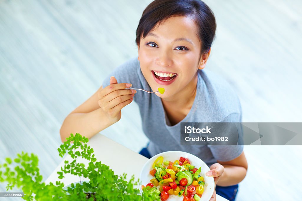 young asian woman eating salad indoor happy young asian woman eating salad indoor 20-24 Years Stock Photo