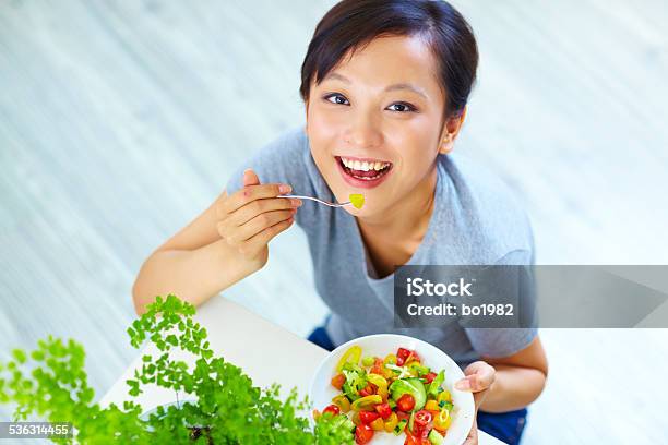 Young Asian Woman Eating Salad Indoor Stock Photo - Download Image Now - 20-24 Years, 2015, Adult