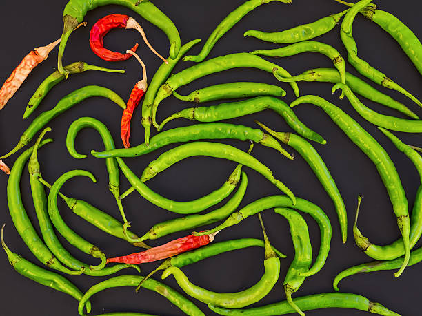 Green and red chili peppers on black