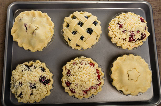 Baking homemade fresh fruit pies Homemade fresh fruit pies on a tray made with strawberries raspberries blueberries blackberries marionberry stock pictures, royalty-free photos & images