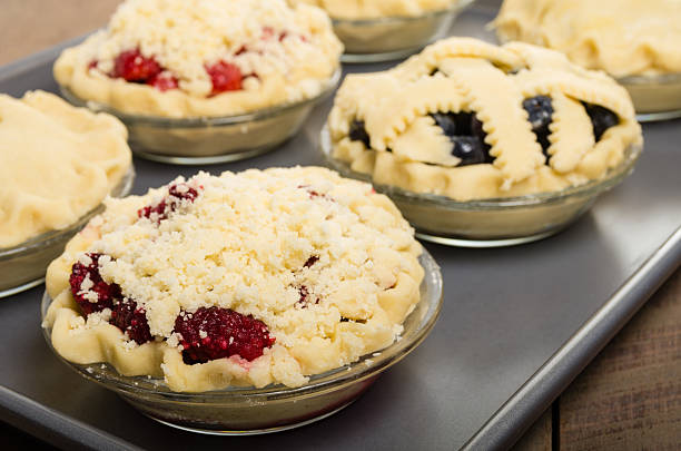 Baking homemade fresh fruit pies Homemade fresh fruit pies on a tray made with strawberries raspberries blueberries blackberries marionberry stock pictures, royalty-free photos & images