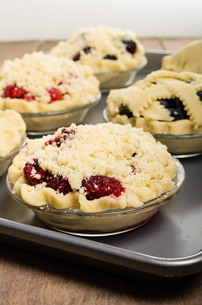 Baking homemade fresh fruit pies Homemade fresh fruit pies on a tray made with strawberries raspberries blueberries blackberries marionberry stock pictures, royalty-free photos & images