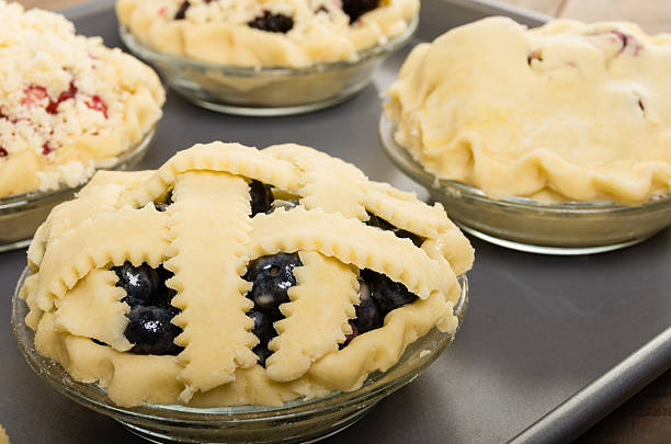 Baking homemade fresh fruit pies Homemade fresh fruit pies on a tray made with strawberries raspberries blueberries blackberries marionberry stock pictures, royalty-free photos & images