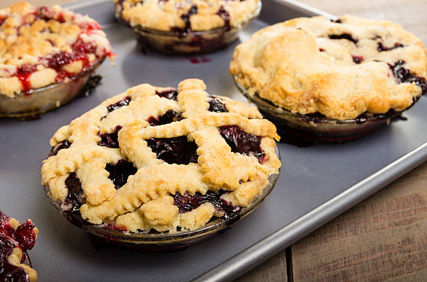 Baking homemade fresh fruit pies Homemade fresh fruit pies on a tray made with strawberries raspberries blueberries blackberries marionberry stock pictures, royalty-free photos & images