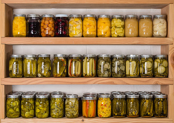 Storage shelves with canned food Storage shelves in pantry with homemade canned preserved fruits and vegetables preserved food stock pictures, royalty-free photos & images