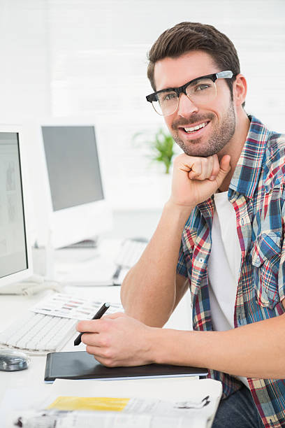 istock Smiling businessman using digitizer at desk 536351293