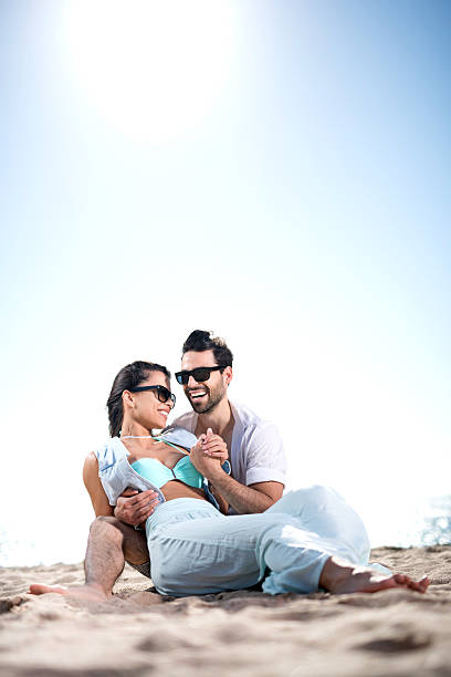 Embraced young couple enjoying in summer day on the beach. Copy space.
