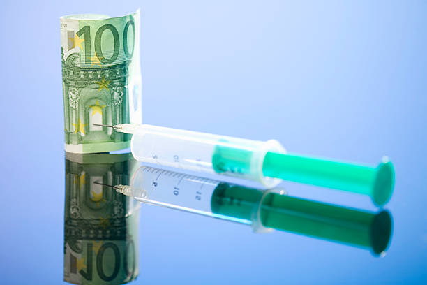 istock 100 Euro banknote and syringe, close up 536352553