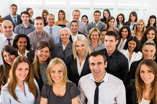 High angle view of large group of smiling business people standing and looking at the camera.   