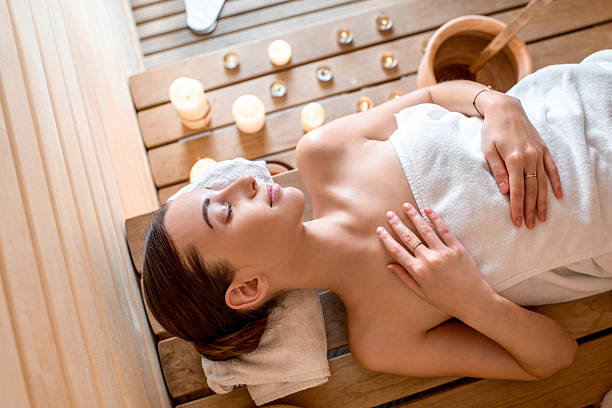 femme dans un sauna - health spa spa treatment towel candle photos et images de collection