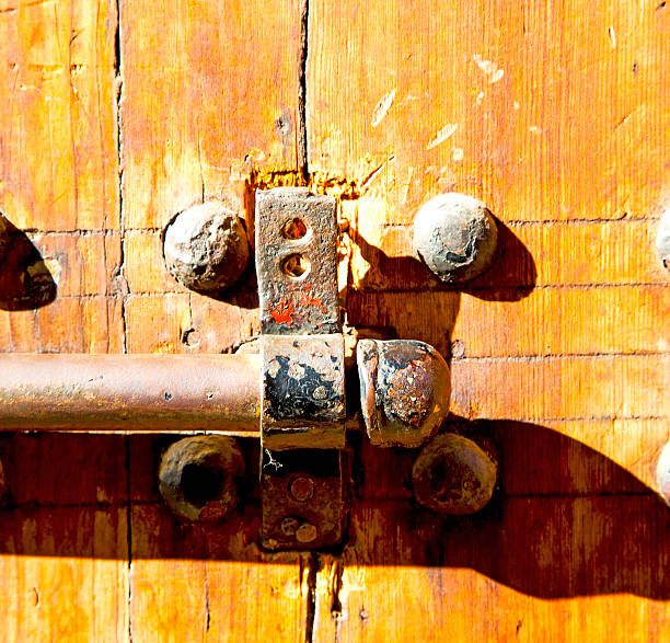 morocco knocker in africa the old wood  facade home and rusty safe padlock