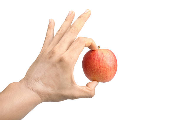 istock red apple in a male hand isolated on white background 536355763