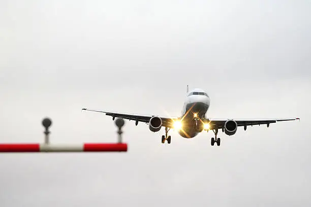 A passenger plane approaching the runway in Frankfurt. The weather is stormy and the pilots have their hands full bringing the plane safely to the ground.