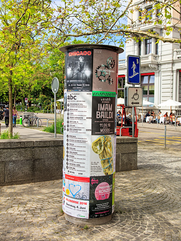 Zurich, Switzerland - 26 May, 2016: theater playbills on the Limmatquai quay, people in the background. Zurich is the largest city in Switzerland and the capital of the Swiss canton of Zurich.