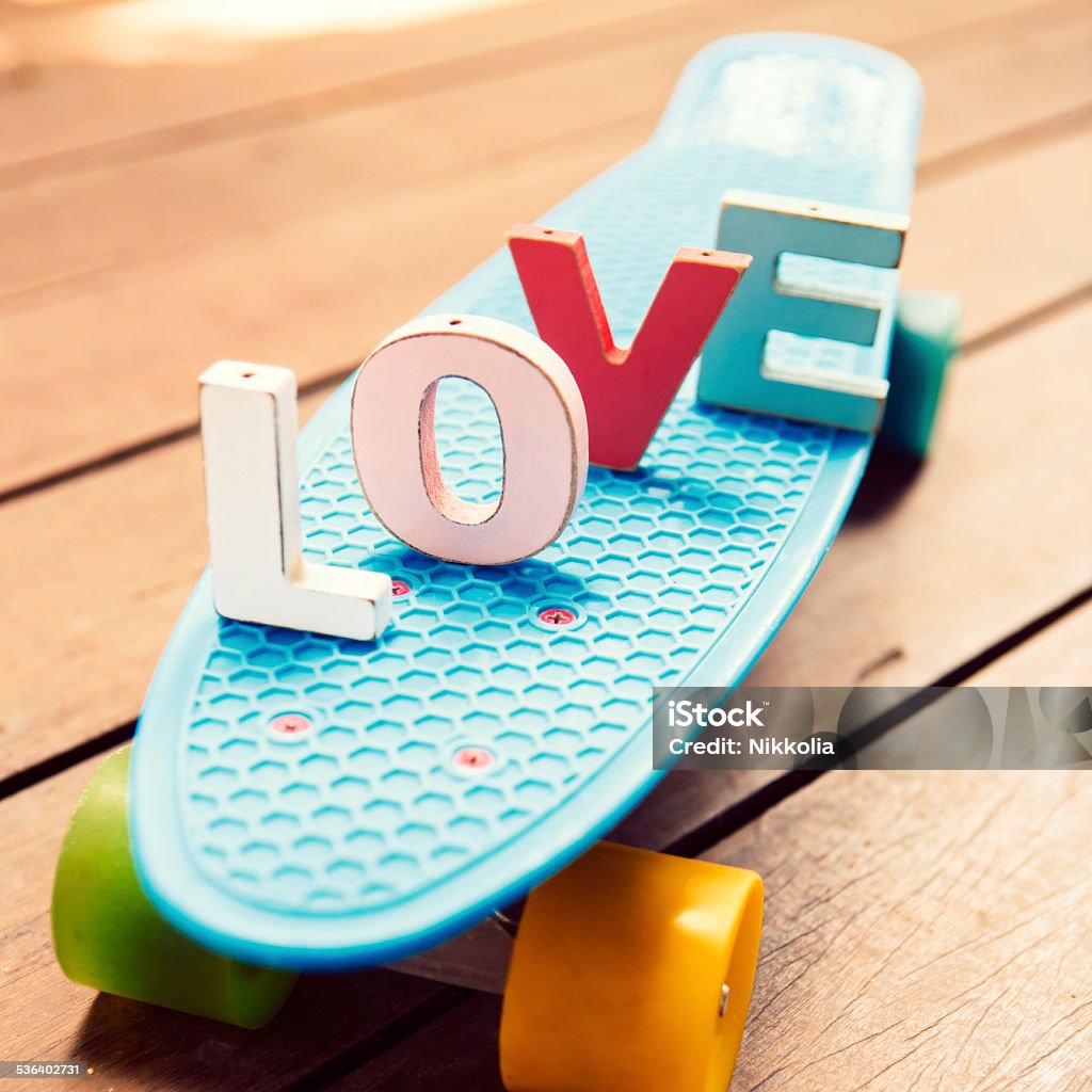 word love on the blue penny board word love made up of colorful wooden letters on the blue pennyboard longboard. February 14, Valentine's Day 2015 Stock Photo