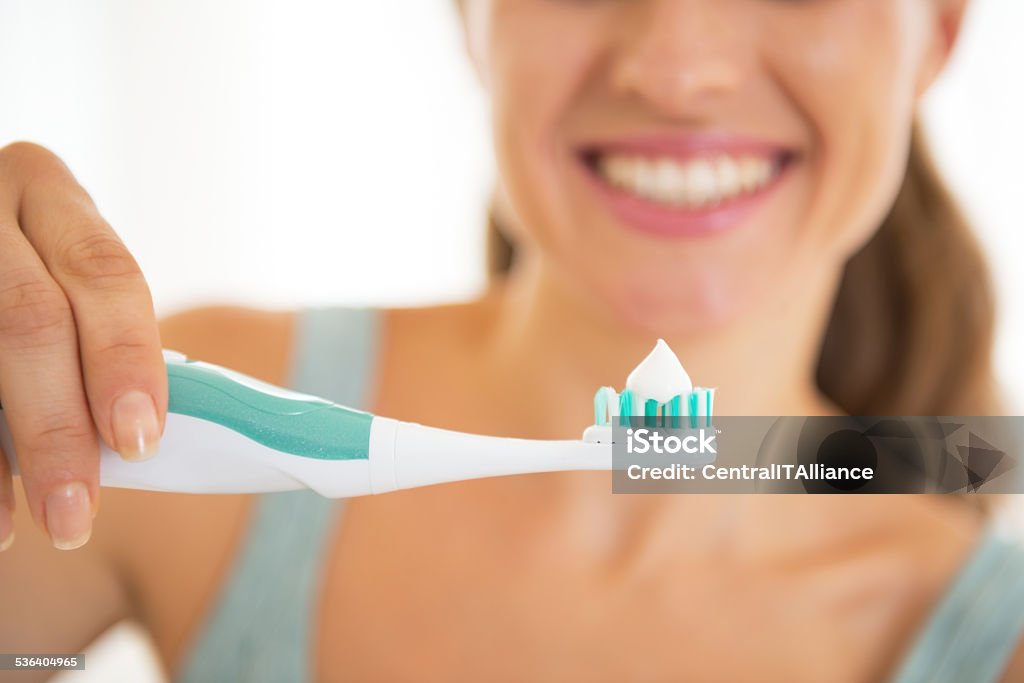 closeup on young woman showing electric toothbrush Closeup on young woman showing electric toothbrush Electric Toothbrush Stock Photo