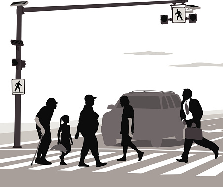 Different types of people walk through a busy cross walk.