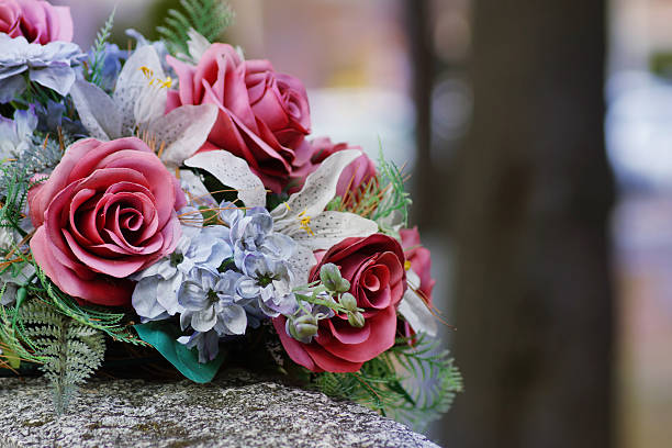 silk flowers on a gravestone, soft focus - blommor grav bildbanksfoton och bilder