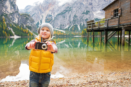 Happy child taking photo while on lake braies in south tyrol, italy