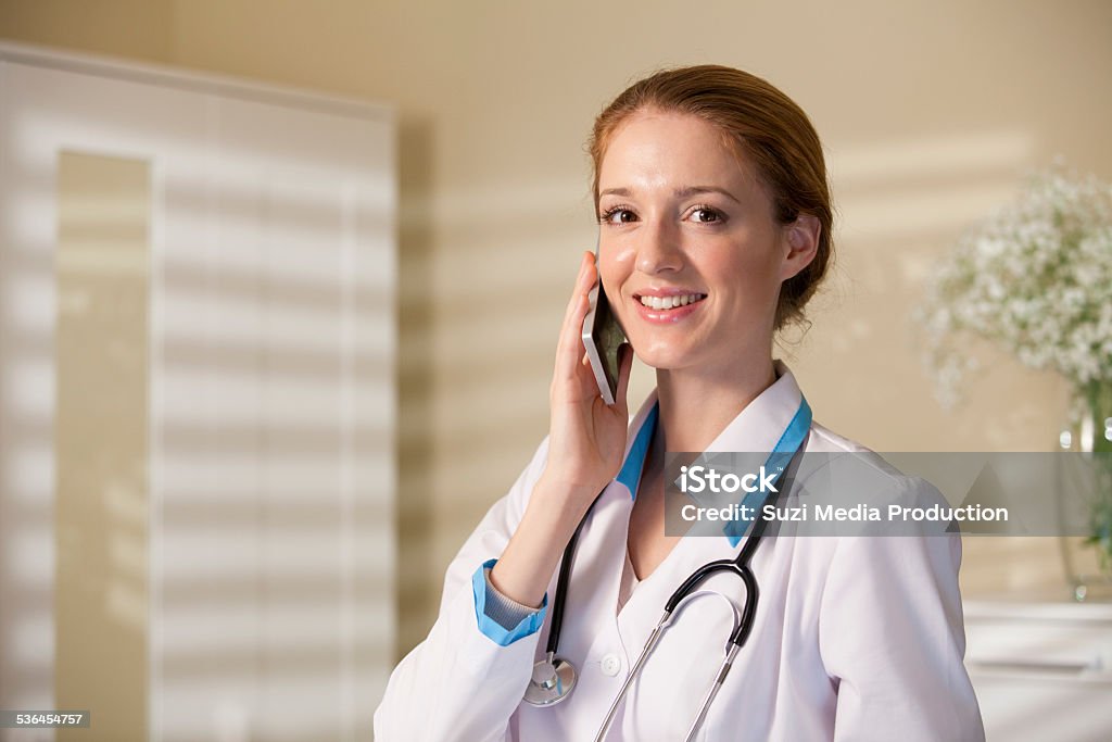 Young beautiful woman doctor with phone Young beautiful woman doctor talking on the phone 2015 Stock Photo