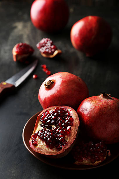 istock Delicious pomegranate fruit on plate on black background 536457803