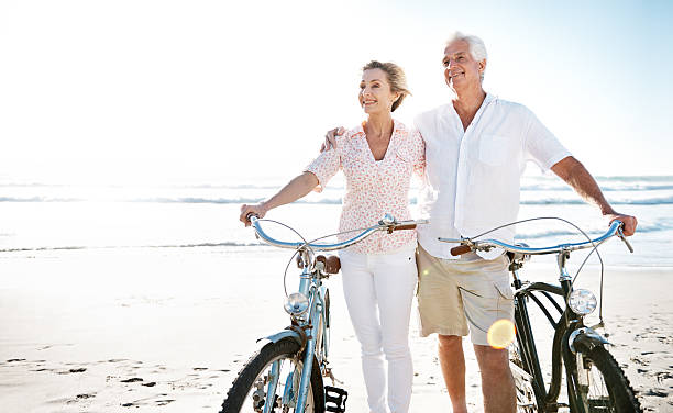 amour n'a pas de date d'expiration - senior couple cycling beach bicycle photos et images de collection