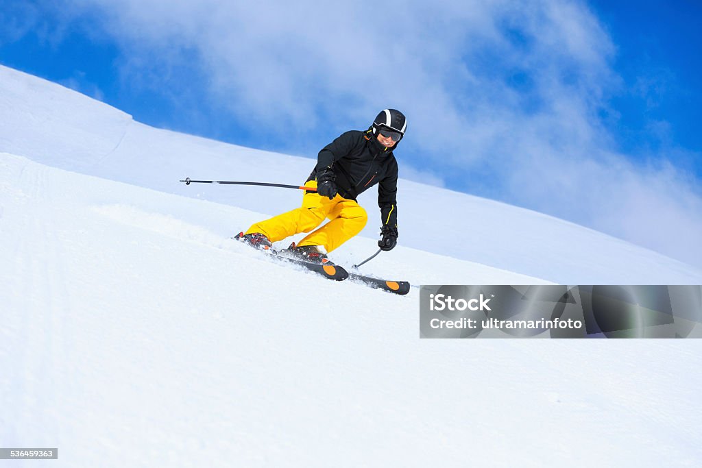 Winter sport  Senior men skier skiing on sunny ski resorts Winter sport. Beautiful senior  men snow skier skiing, enjoying on sunny ski resorts. Skiing carving at high speed, chunks of snow flying against the beautiful blue sky in the background. Shot with Canon 5DMarkIII, developed from RAW,  Adobe RGB color profile. Shallow DOF  for soft background. 2015 Stock Photo