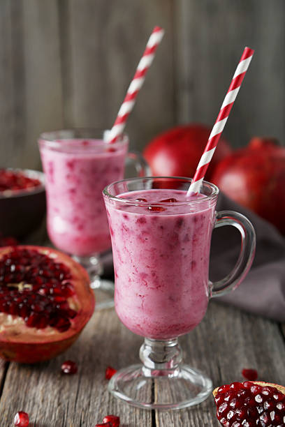 istock Pomegranate smoothie in glass on grey wooden background 536461499