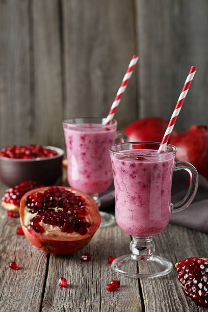 istock Pomegranate smoothie in glass on grey wooden background 536461505