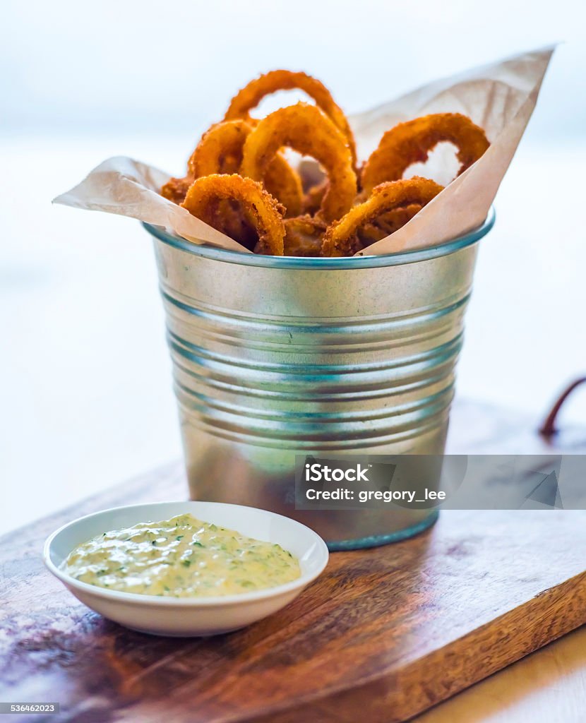Onion rings Deep fried onion rings with garlic sauce on wooden board 2015 Stock Photo