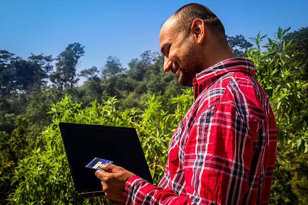 istock Indian Boy Holding Laptop and Debit Card looking happy 536462483