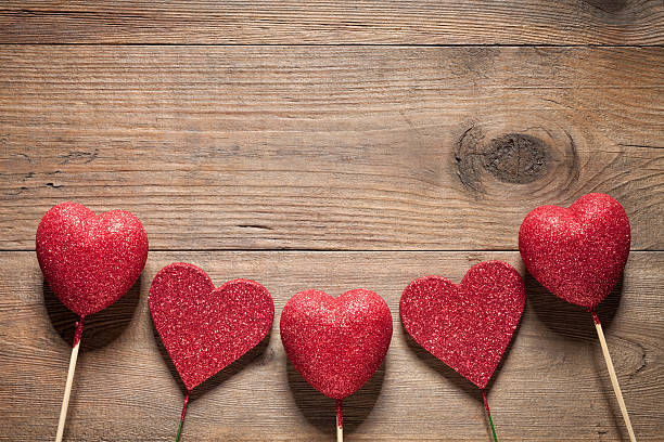 istock Glitter hearts on old wooden table 536462575