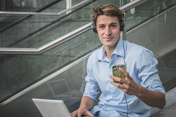 young model hansome blonde man headphone and notebook stock photo