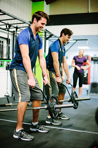 istock Young man lifting a barbell in the gym 536507621