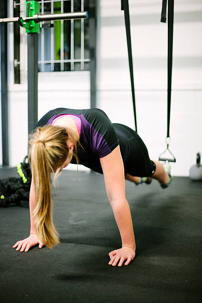 istock Young, blonde woman using a suspension trainer in a gym 536507669