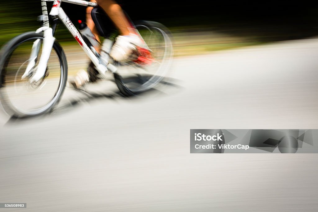 Motion blurred bicycle Cyclist on a road bike going fast (motion blur technique is used to convey movement; colour toned image) 2015 Stock Photo